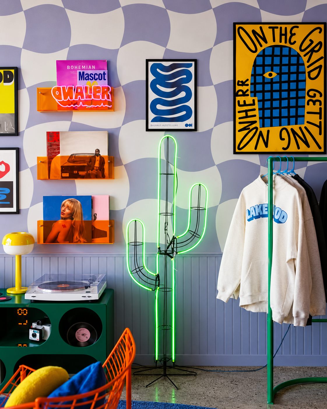 Merchandise wall with records, a neon cactus, and apparel