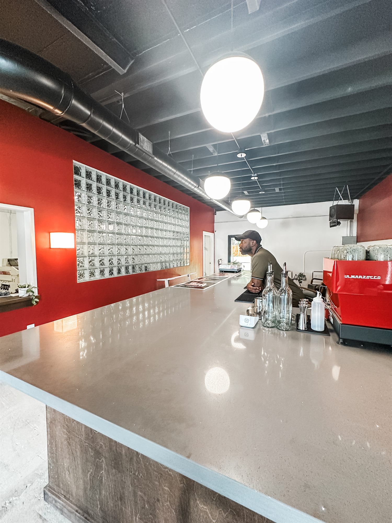 Service counter with a glass block window and an exposed black ceiling