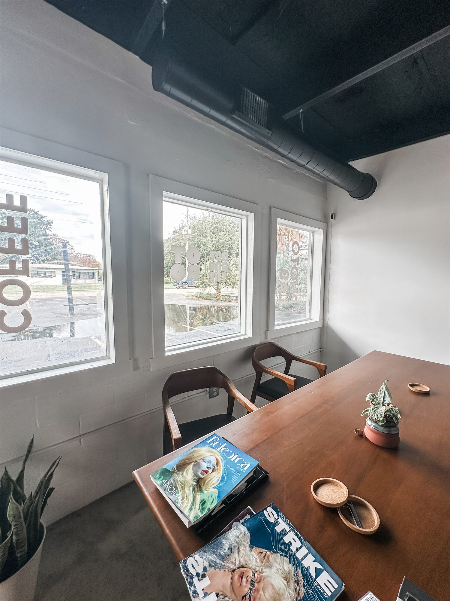 Window seating area with a wood table and magazines