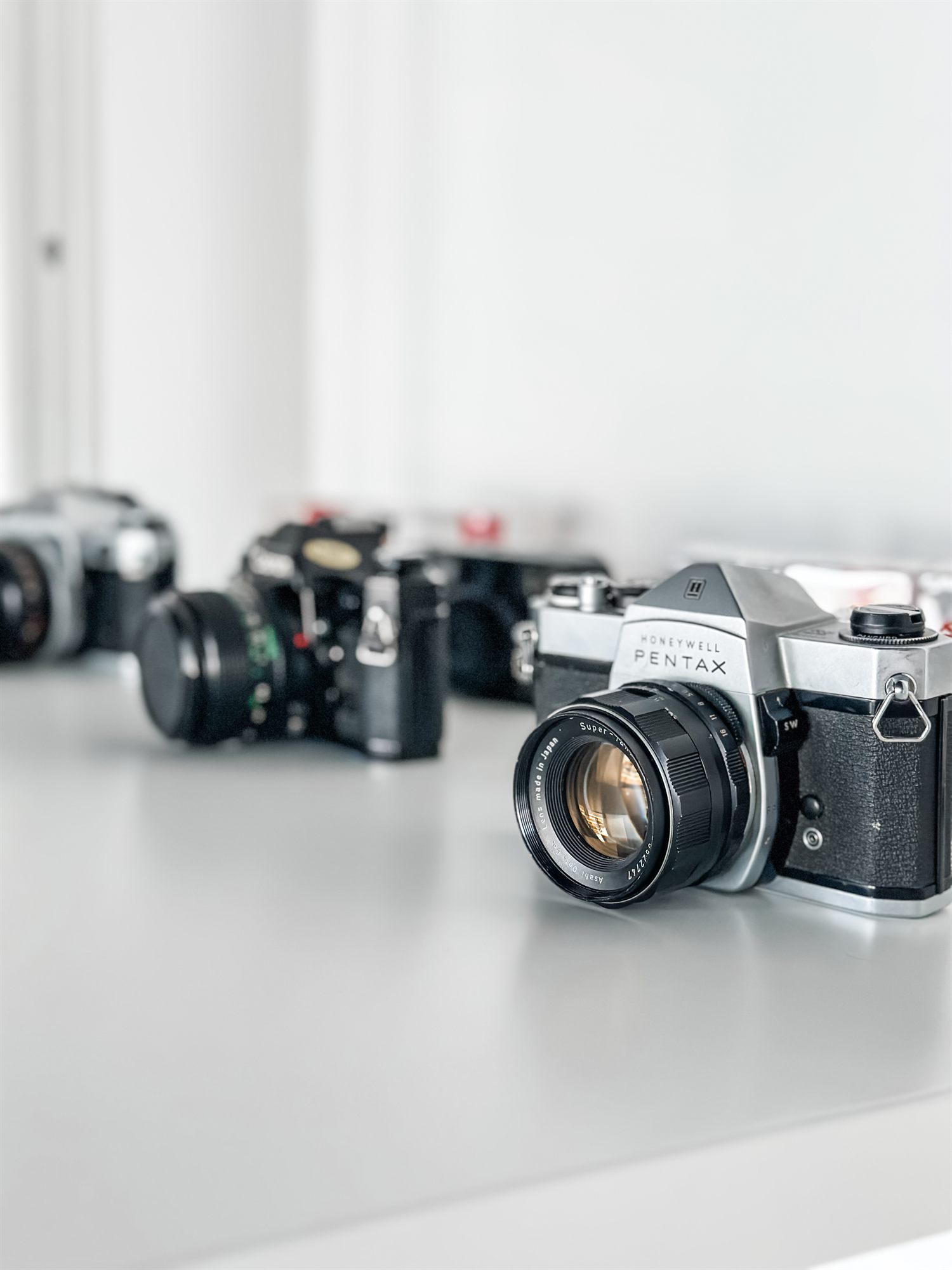 Film cameras displayed on a white counter